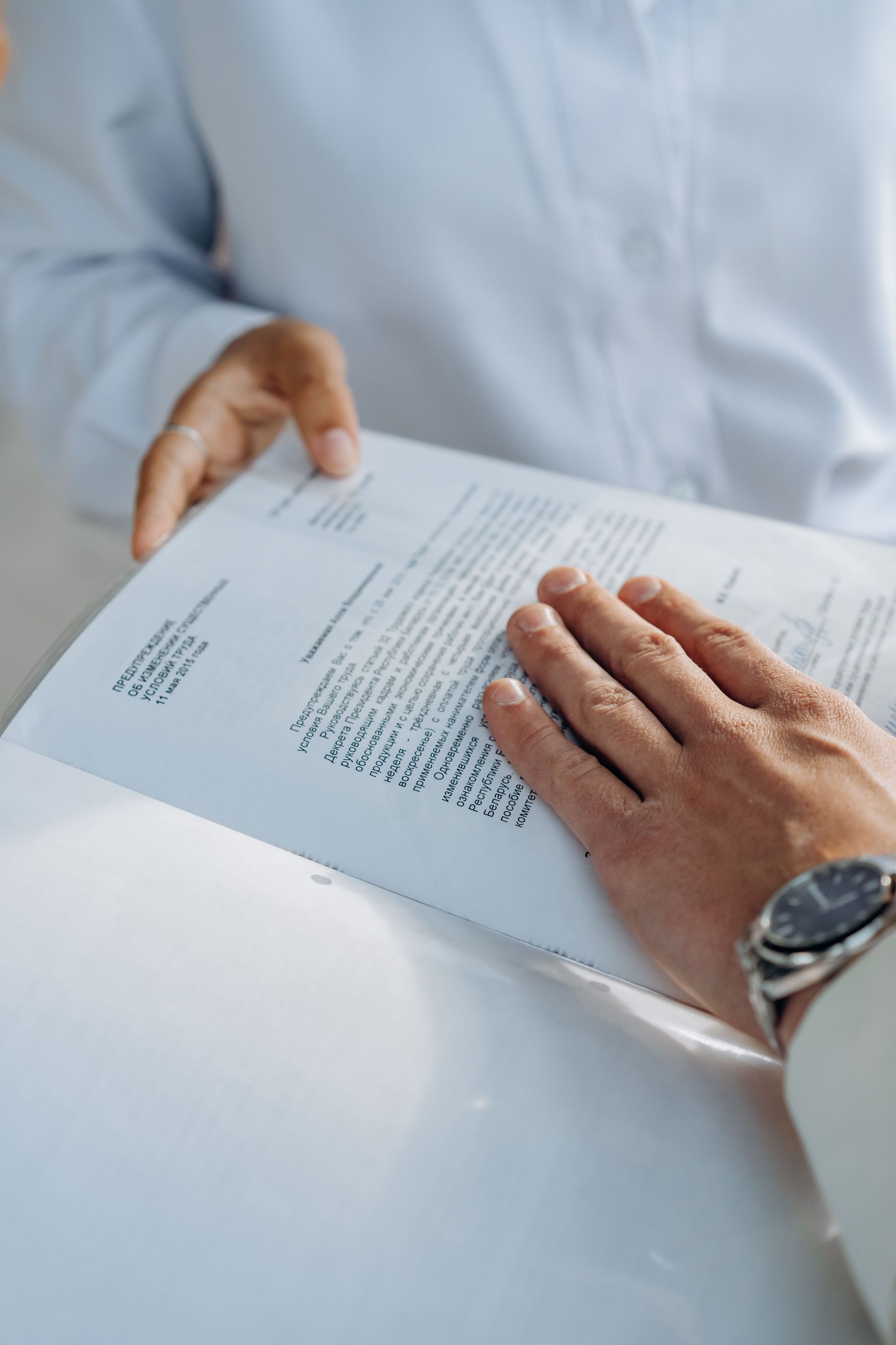 Close-up of hands reviewing a business agreement document. Professional setting.